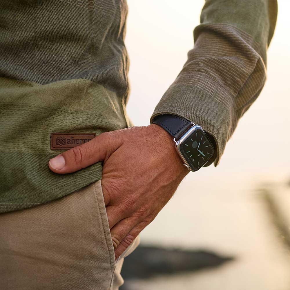 Mann hat seine Hand in die Hosentasche gesteckt und am Handgelenk trägt er eine Apple Watch mit Lederarmband von Goodwilhelm