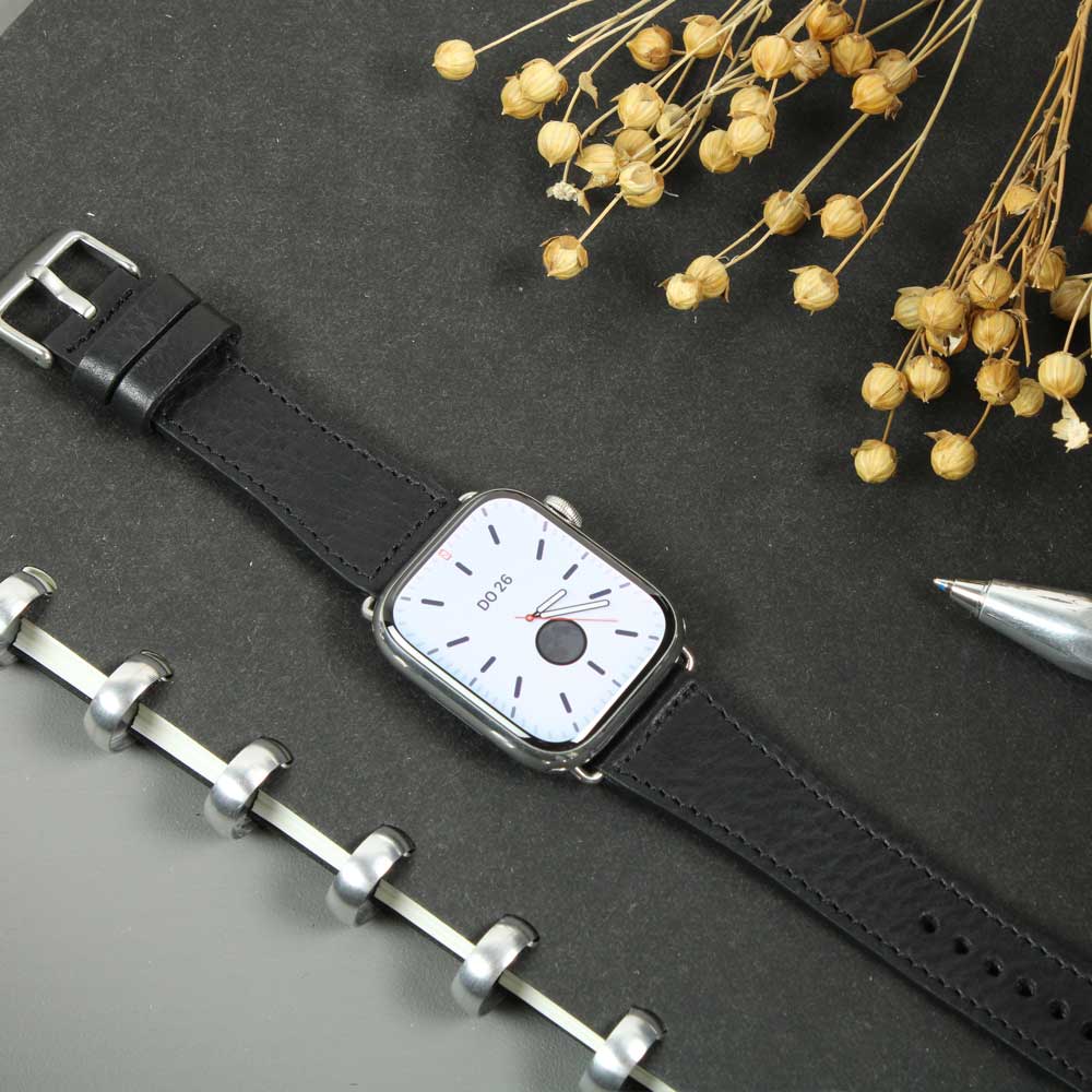 Auf einem Tisch liegt eine Uhr mit einem schwarzen Lederarmband von Goodwilhelm