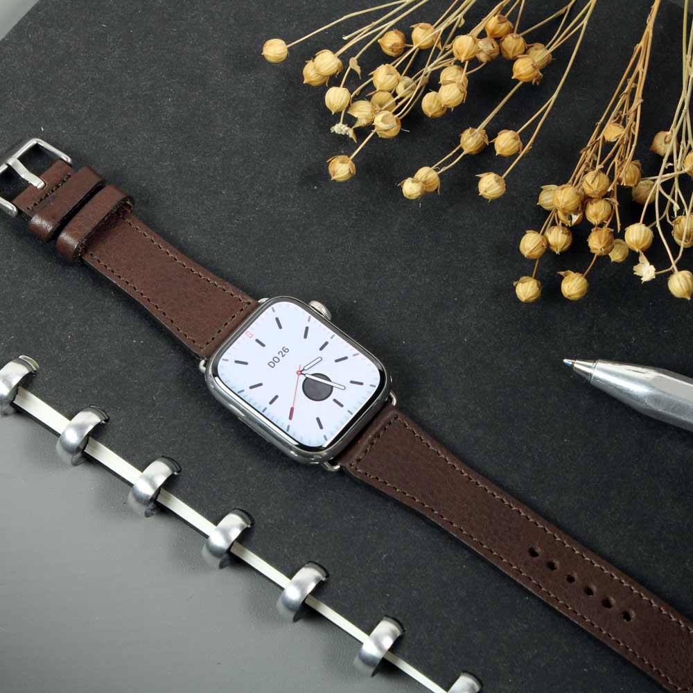 Auf einem Tisch liegt eine Uhr mit einem dunkel braunem Lederarmband von Goodwilhelm